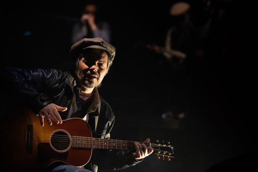 artista sul palco con una chitarra