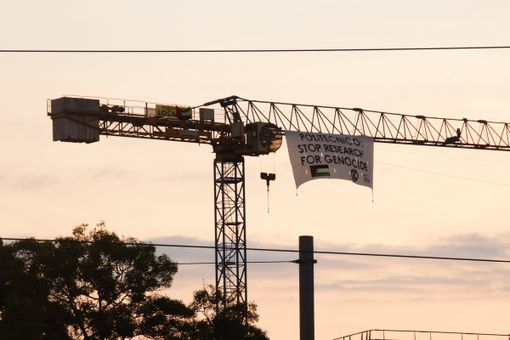 striscione appeso a una gru