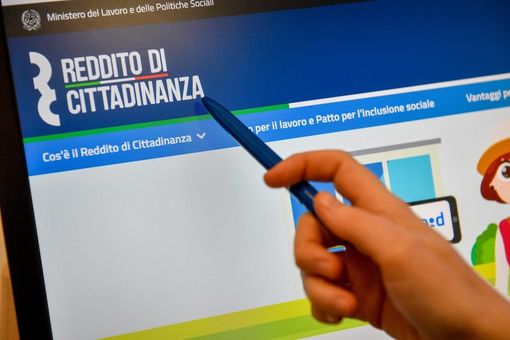 Richiesta del reddito di cittadinanza con una mano che indica la schermata del computer Richiesta del reddito di cittadinanza con una mano che indica la schermata del computer