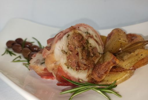 Rolata di coniglio bardata al bacon contornata di patate al forno