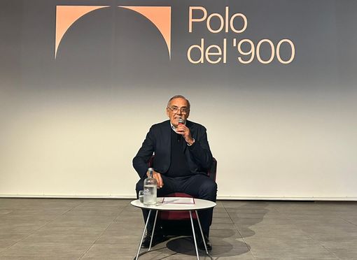 Uomo che parla su un palcoscenico scuro Uomo che parla su un palcoscenico scuro