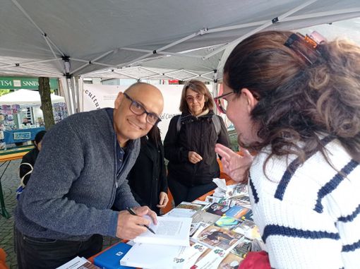 Scrittore che firma copie di un libro Scrittore che firma copie di un libro