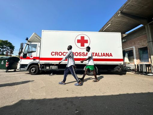 Bus della Croce Rossa e due migranti