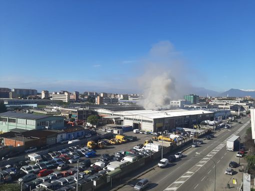 colonna di fumo che si solleva da un'azienda
