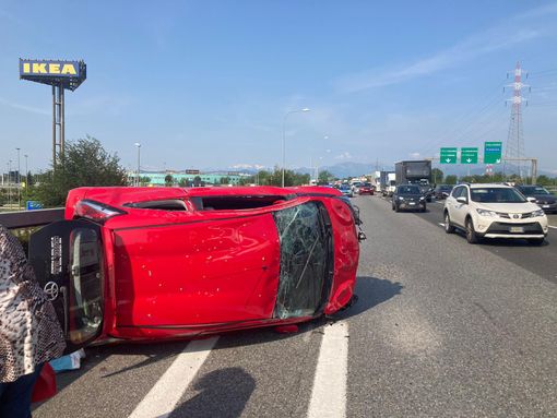 Una vettura ribaltata su un lato dopo uno scontro in tangenziale