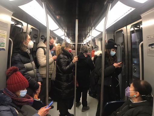 Persone in metropolitana con mascherine
