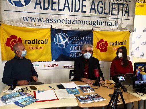tavolo con persone sedute e bandiere di partito