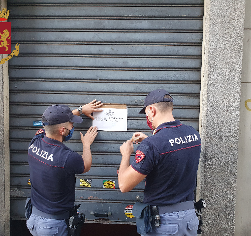 Poliziotti mettono cartello di chiusura imposta per un locale bar