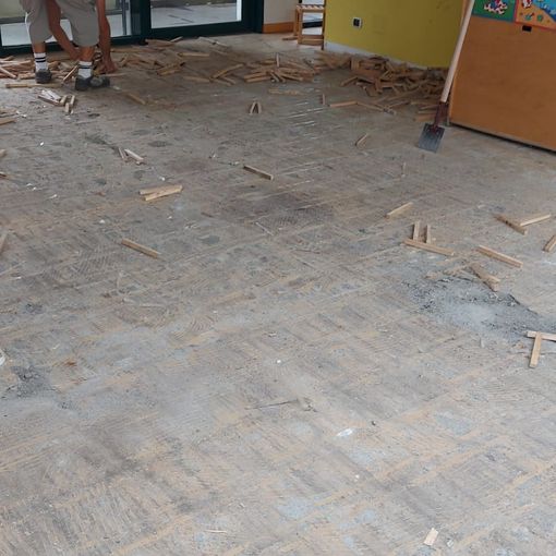 La rimozione dei listelli di legno del pavimento dell’asilo di Villar Perosa