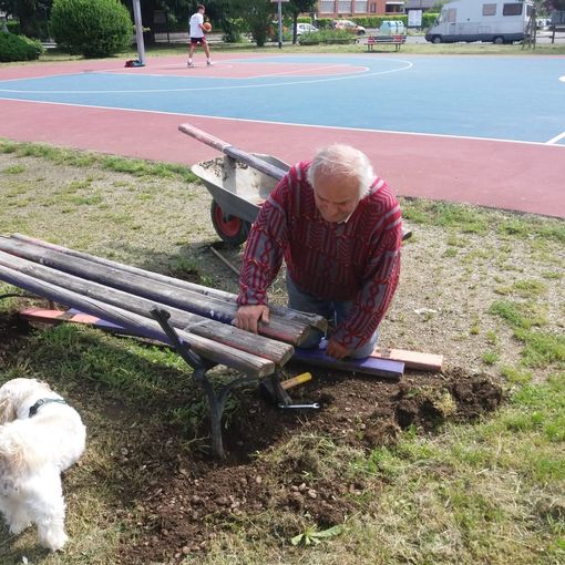 Agostino Crociani al lavoro per rimettere a posto la panchina rotta dai vandali