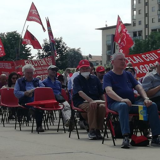 persone sedute con bandiere Cgil