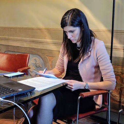 Chiara Appendino seduta davanti al pc e con dei documenti in mano