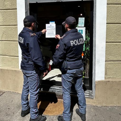 Poliziotti davanti a una saracinesca chiusa