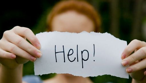 Ragazza tiene in mano cartello con la scritta &quot;help&quot;