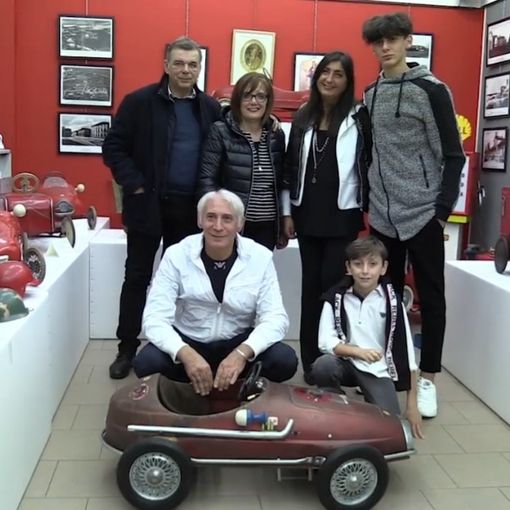 Persone accovacciate vicino a un modellino di auto in scala