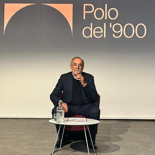 Uomo che parla su un palcoscenico scuro