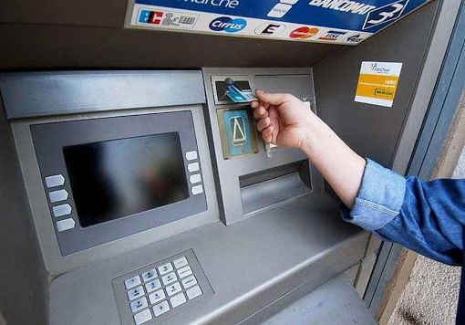 sportello bancomat con persona che fa il prelievo