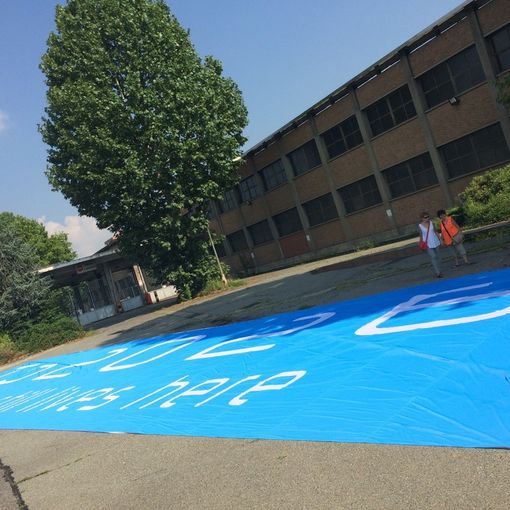 Lo striscione pro-Olimpiadi Torino 2026 all'ex-Thyssen: oggi flashmob