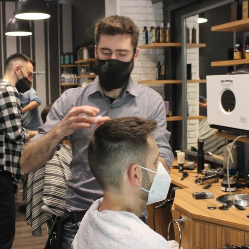 Barbiere al lavoro con un cliente
