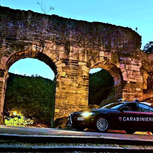 auto dei carabinieri davanti a un arco