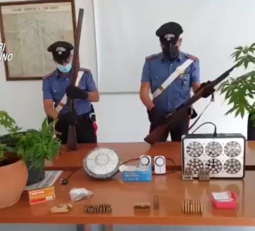carabinieri di fronte a un tavolo con cose sequestrate