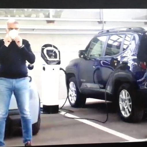 due uomini davanti a due auto elettriche