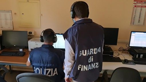 militari della Guardia di Finanza all'opera davanti a un pc