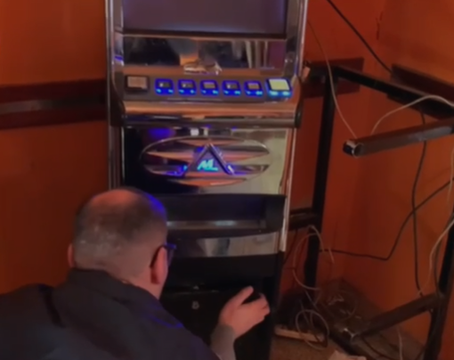 uomo della guardia di finanza con slot machine