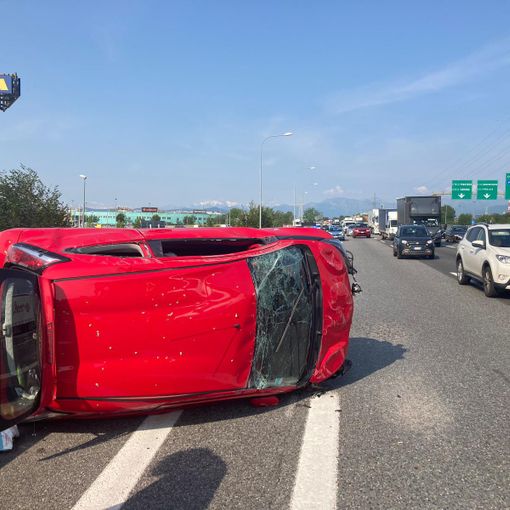 Una vettura ribaltata su un lato dopo uno scontro in tangenziale