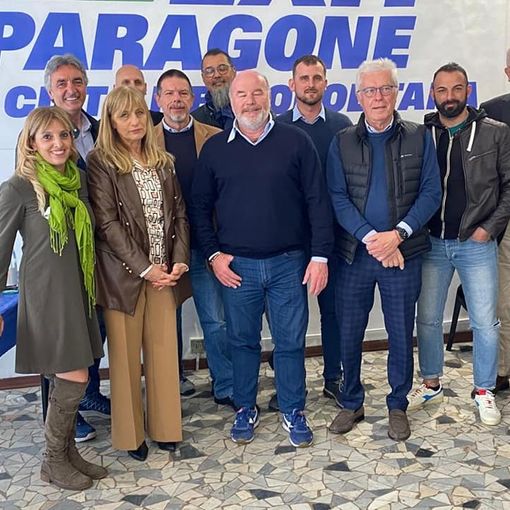 foto di gruppo davanti a simbolo di partito