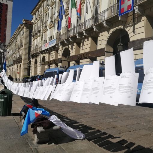 lettere di licenziamento appese a un filo in piazza castello a Torino