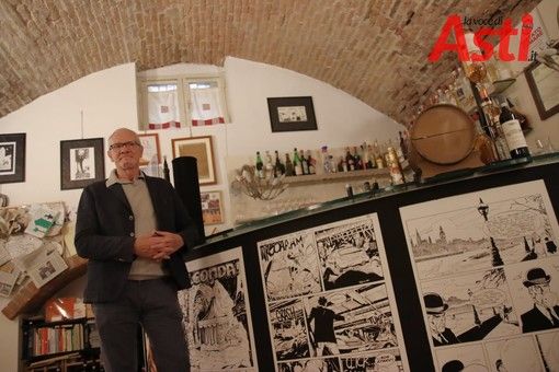 Luigi Piccatto appoggiato a un bancone con tavole disegnate