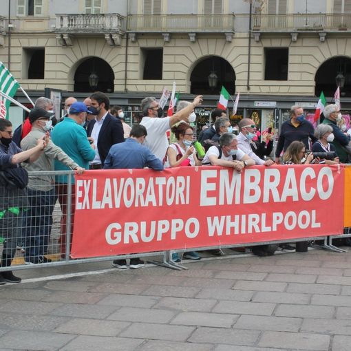 Lavoratori in protesta dietro una transenna