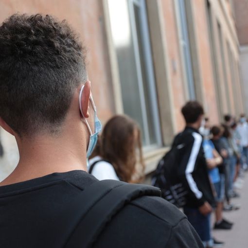 ragazzi in coda all'ingresso a scuola