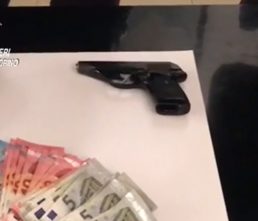 Soldi e una pistola su un tavolo dei carabinieri