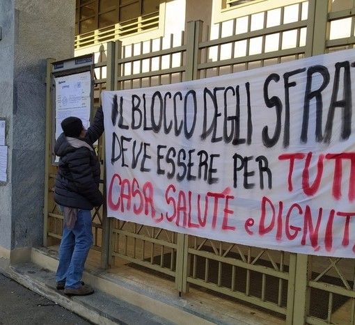 Persona che appende uno striscione sugli sfratti