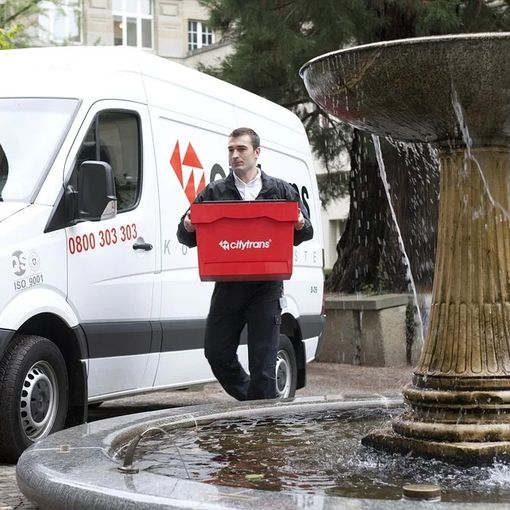 Corriere che consegna un pacco scendendo dal suo mezzo