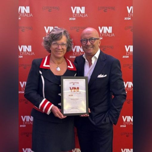 due persone in piedi con un premio in mano