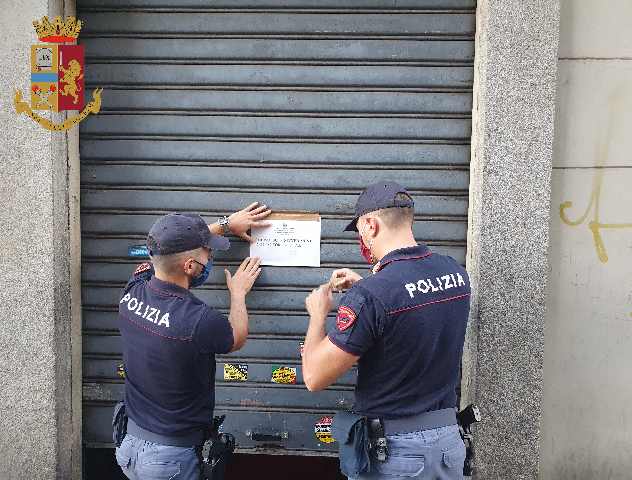 Poliziotti mettono cartello di chiusura imposta per un locale bar