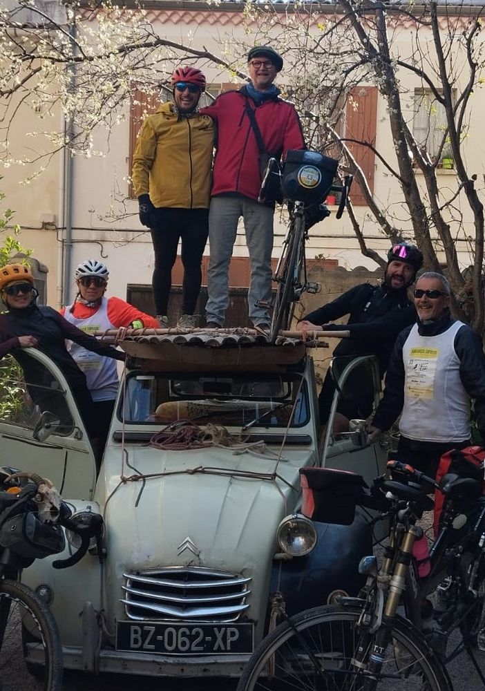 Davide Rivoira con i compagni di viaggio, a sinistra, sul tettuccio della Citroën dell’artista di Arles