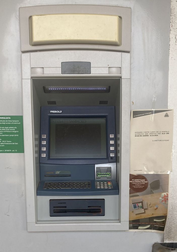 Il bancomat con il foglio che annuncia la chiusura