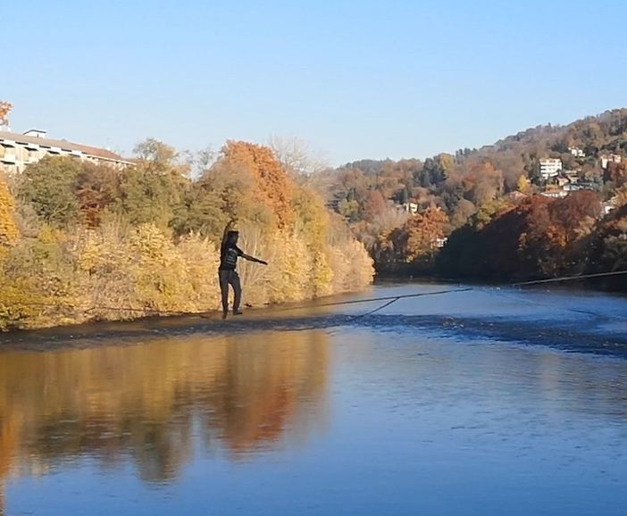 Camminano sul filo del Po sopra una corda tesa da una sponda all’altra: la magia dei funamboli incanta i passanti [FOTO E VIDEO]