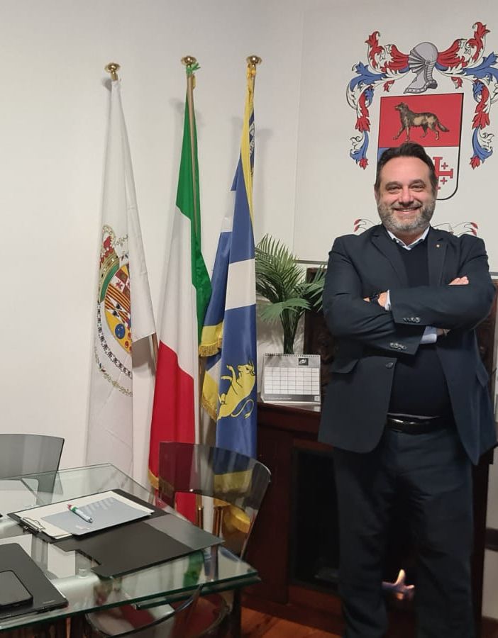 Persona che sorride dietro una scrivania