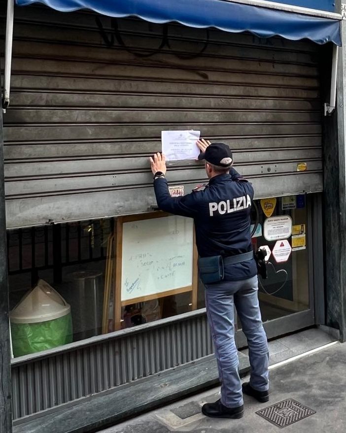 Poliziotto che affigge un cartello di chiusura