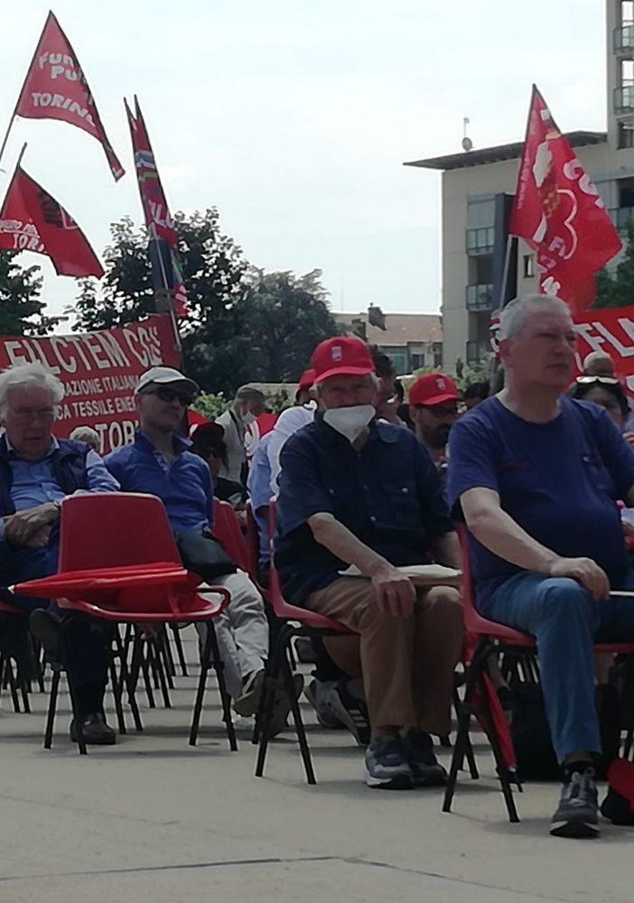 persone sedute con bandiere Cgil