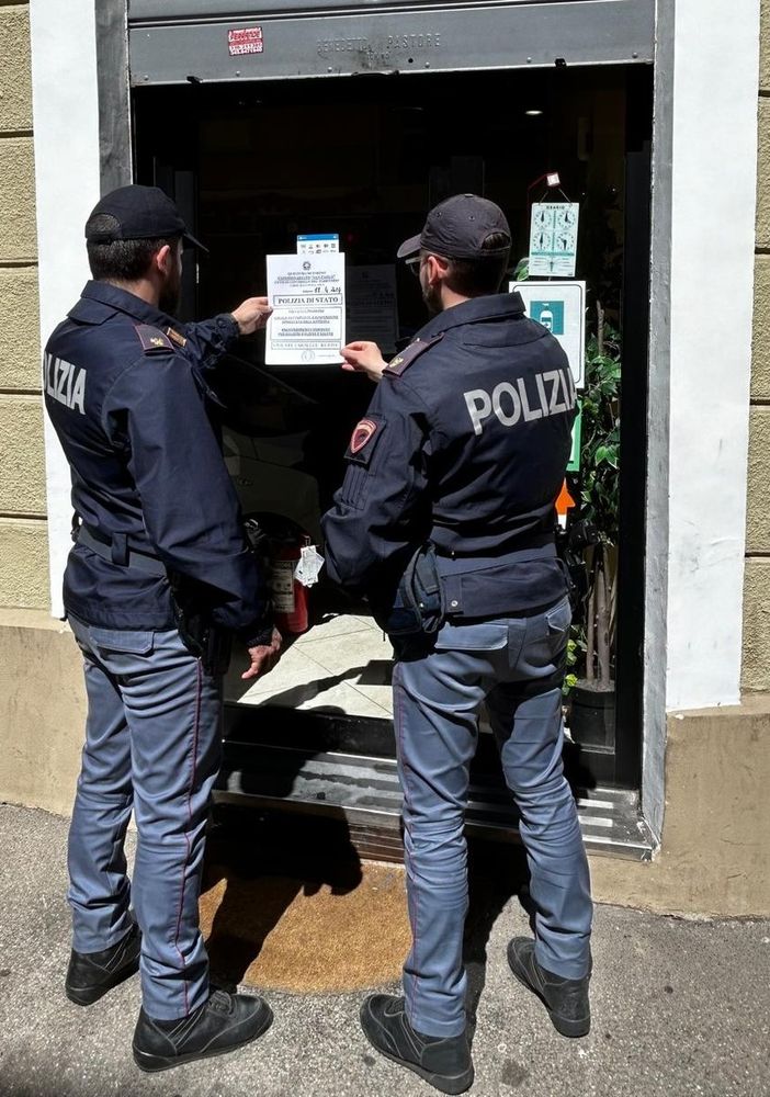 Poliziotti davanti a una saracinesca chiusa