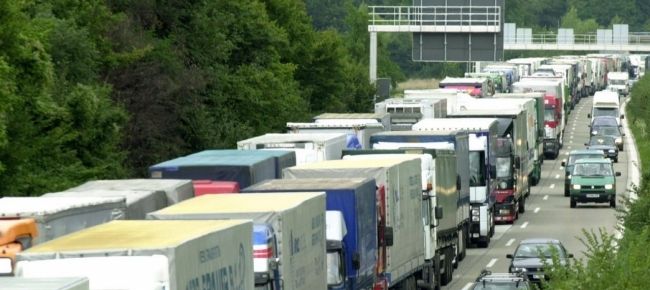Una colonna di tir in coda su una strada trafficata