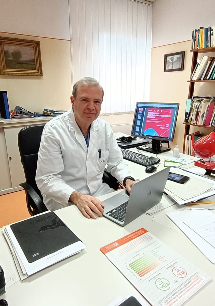Dario Mazzucco in camice seduto alla sua scrivania