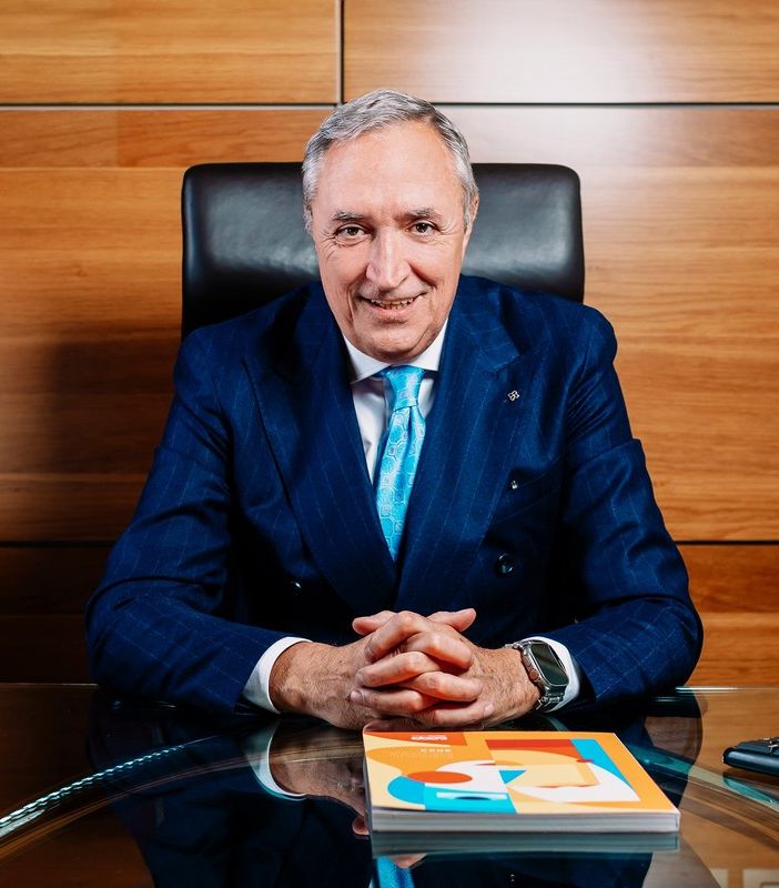 Uomo in primo piano seduto alla scrivania