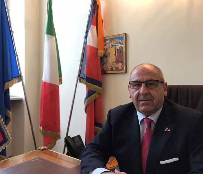 Uomo in giacca e cravatta seduto alla scrivania